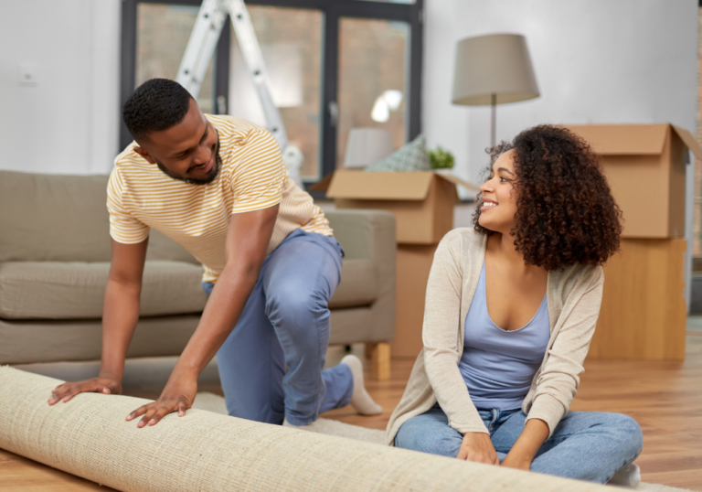 young couple fixing the floor carpet together questions to ask before moving in together