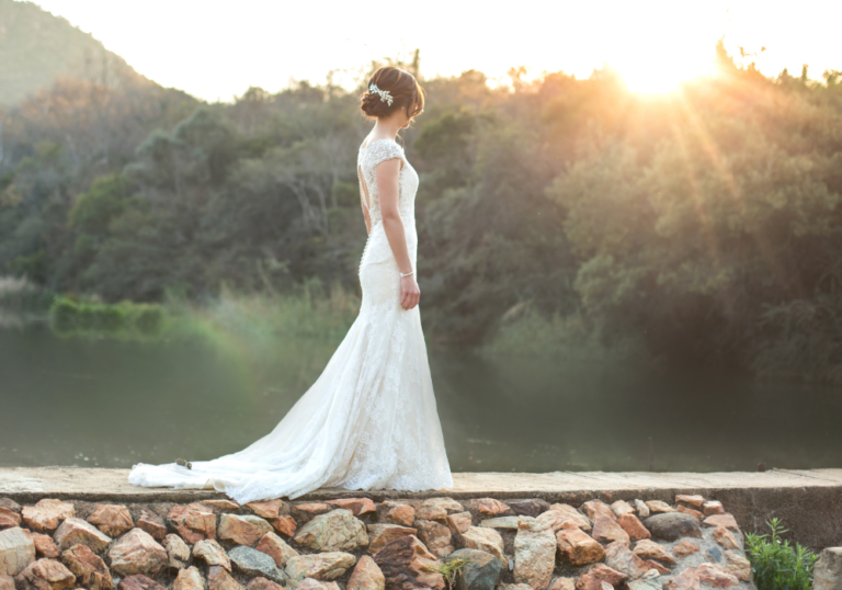 bride standing in wedding gown by lake letter to wife on wedding day