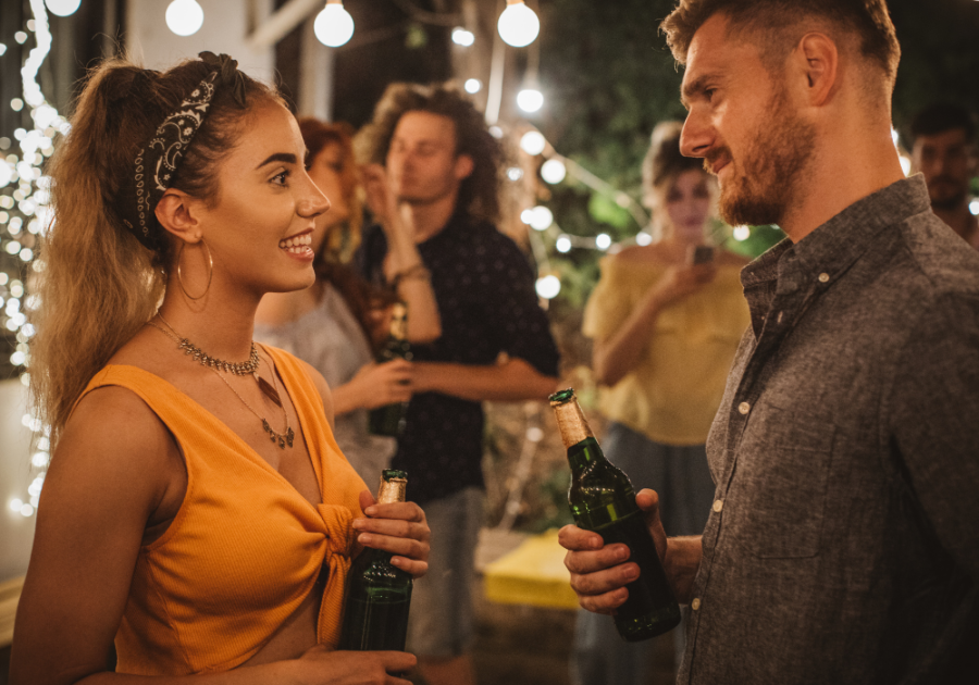 man and woman talking at a party signs he's not into you