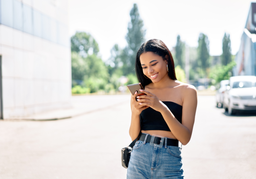 woman smiling while using phone should I text him