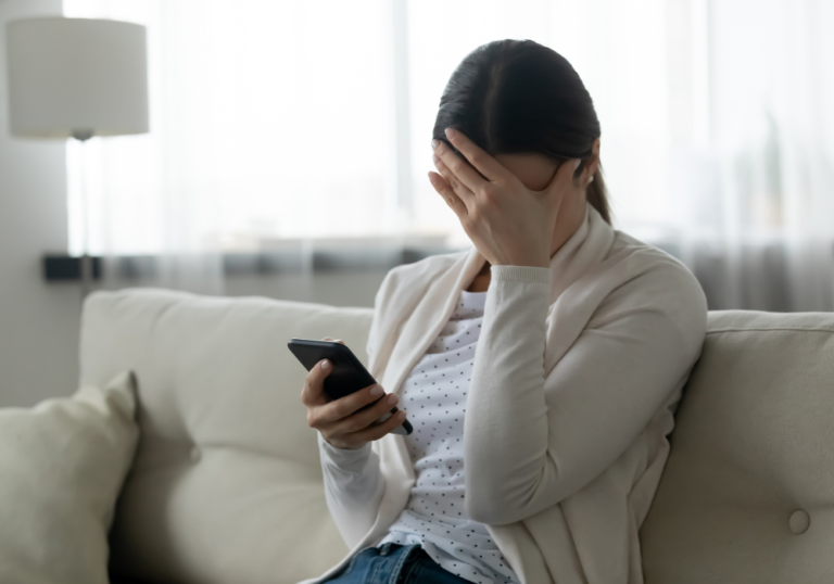 woman holding head while using phone feeling like an option in a relationship