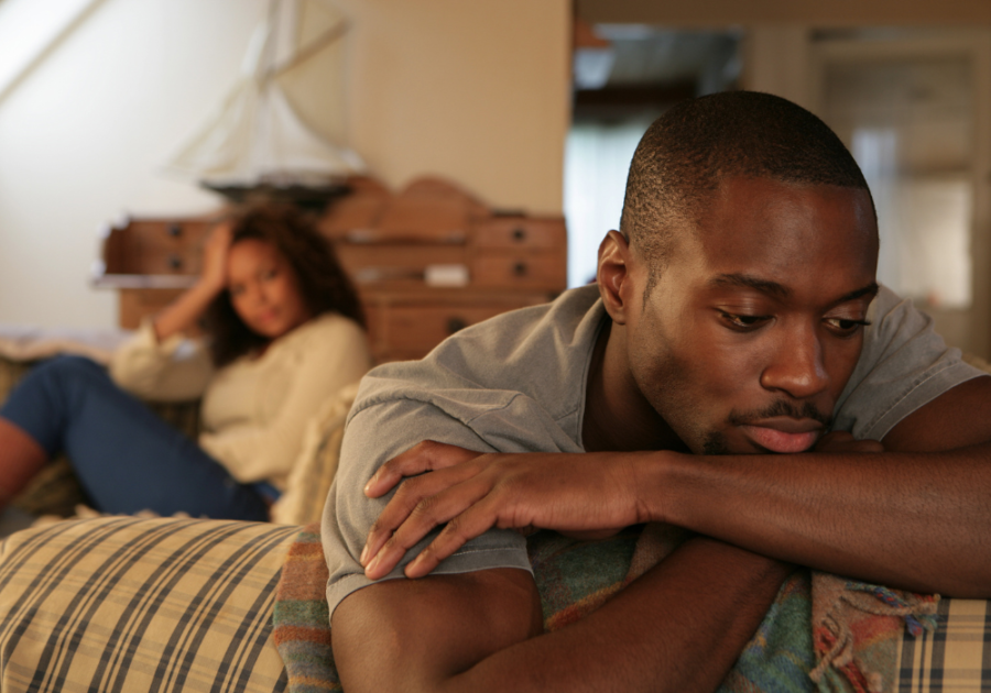 man looking unhappy while leaning in couch signs of a weak man in a relationship