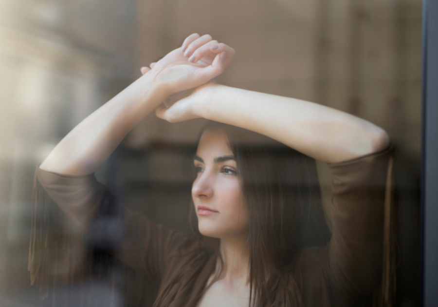 woman leaning over the window feeling trapped in a relationship