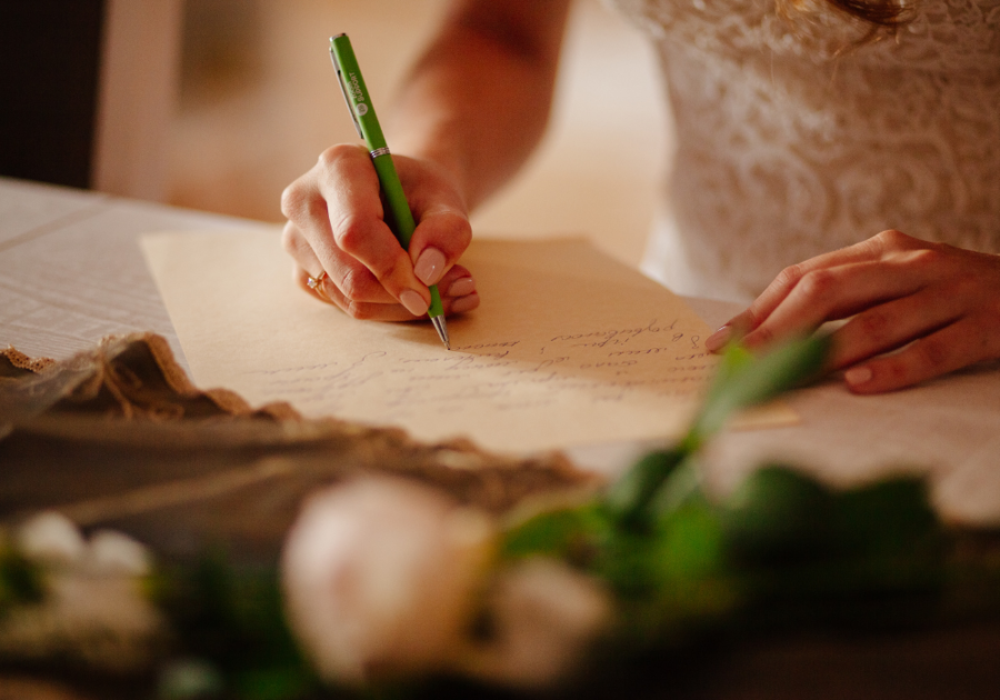 person writing on a paper romantic wedding vows to make him cry