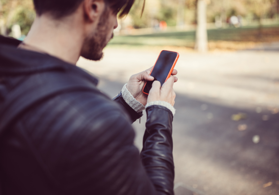 man using phone while outside should I text my ex