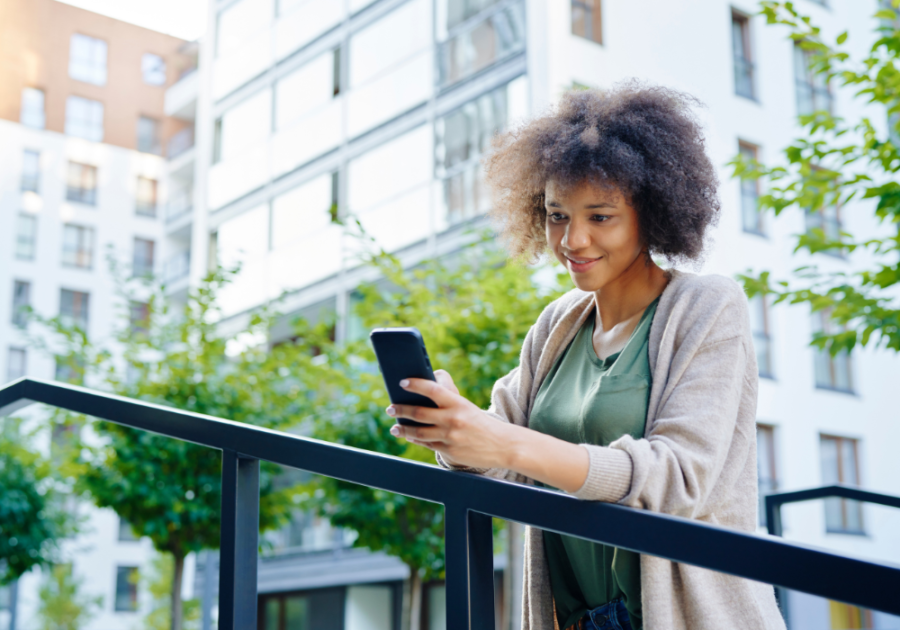 woman looking at phone while she's outside good morning text to your crush