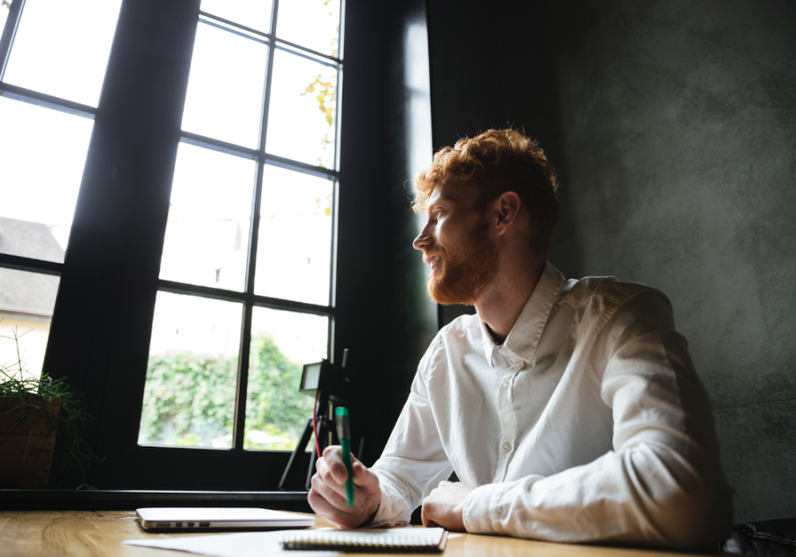 man looking at the window holding pen love letters for girlfriend