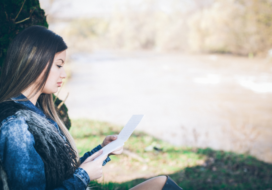 woman reading under the shade of tree love letters for girlfriend