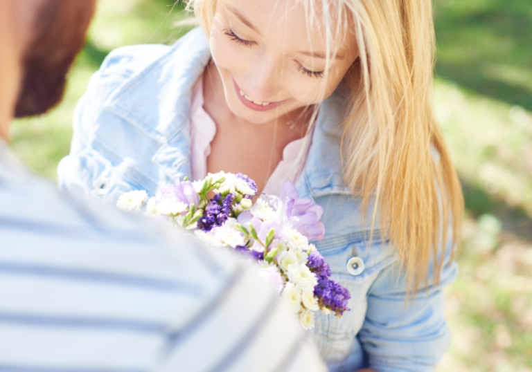 woman smiling while looking at the flowers do i like him or the attention