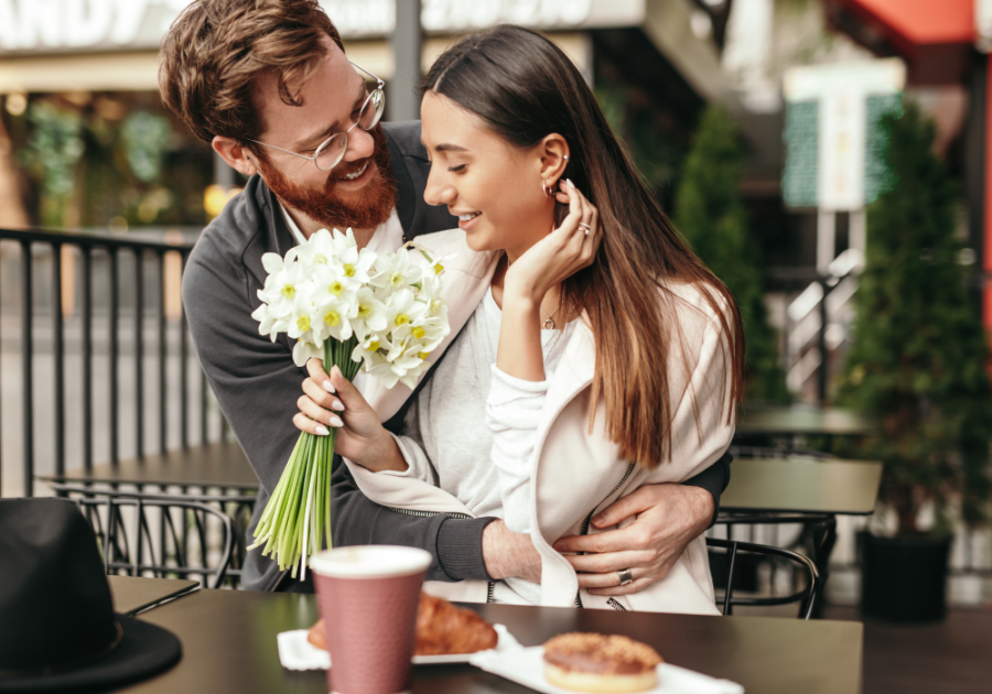 woman holding flowers while man is hugging her compliments for girlfriend