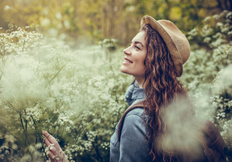 woman with a hat enjoying the field signs of a heyoka empath