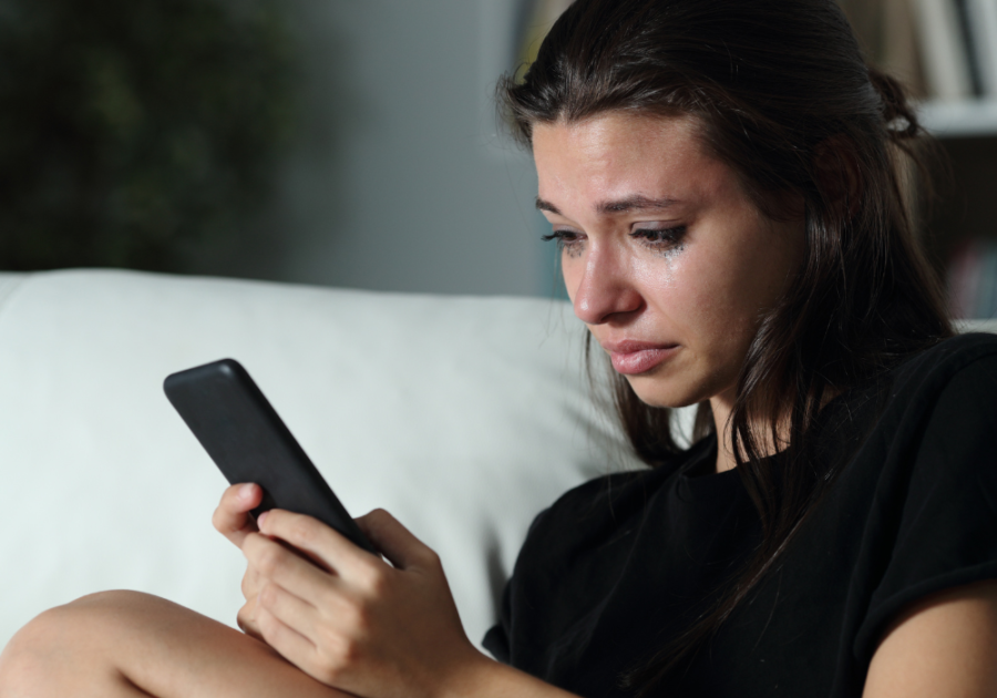 woman with smudged make-up looking at phone how to reject someone nicely