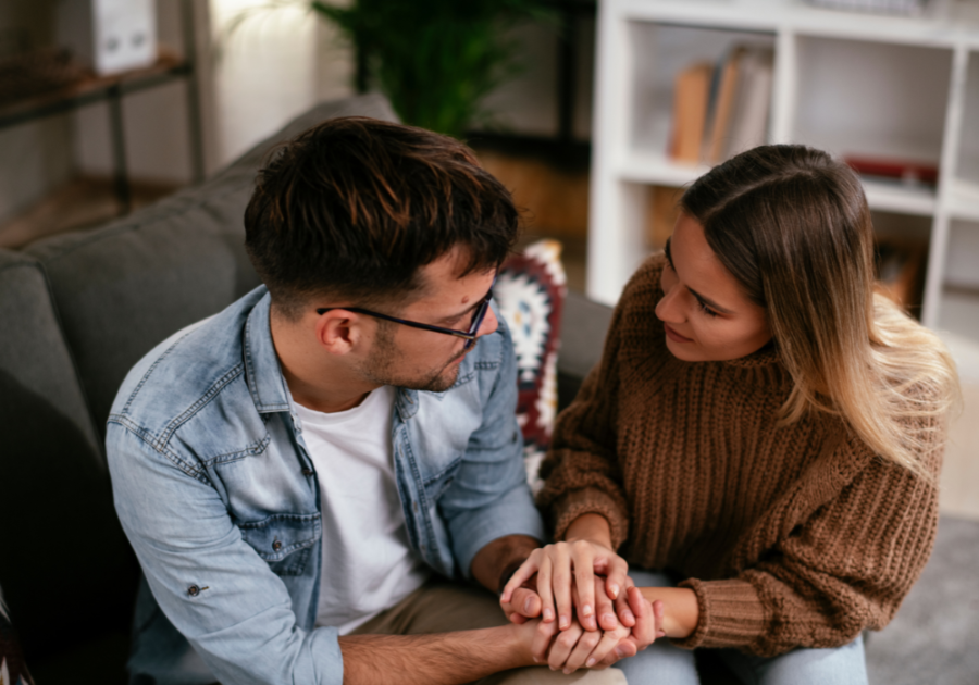 couple holding each other's hands while talking intently triggers for empaths