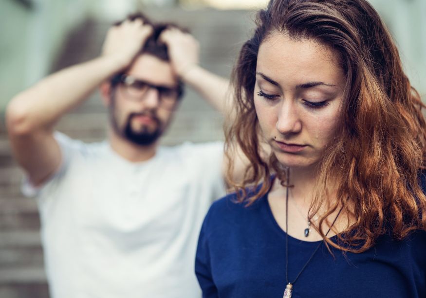 man in background emotional woman looking sad how to know it's time to break up