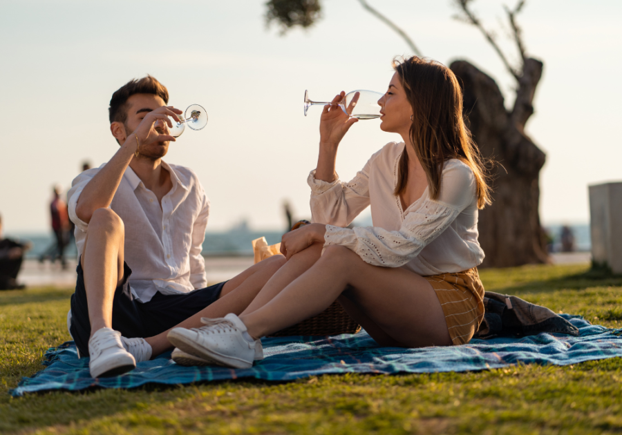 couple having wine tasting on blanket Last-Minute Date Ideas