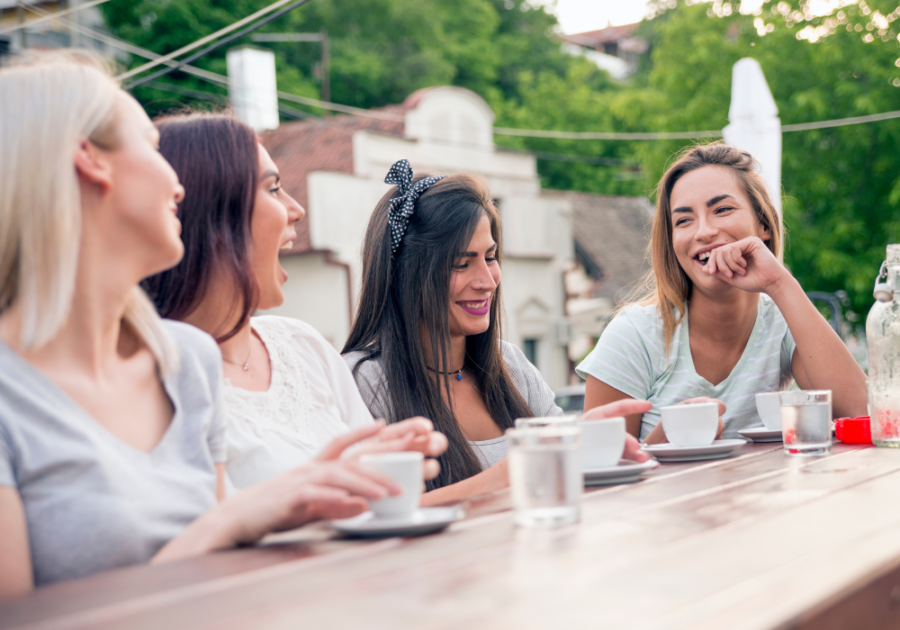 women sitting a outdoor table drinking coffee Paranoia Questions Game