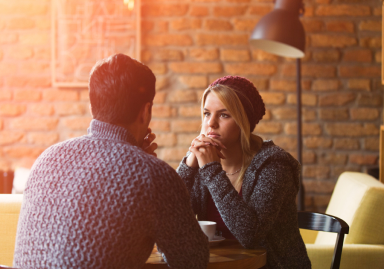 couple sitting at table signs of Unintentional Gaslighting