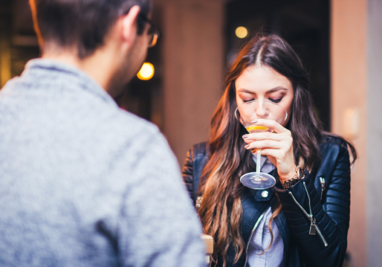 woman drinking cocktail with man dating red flags