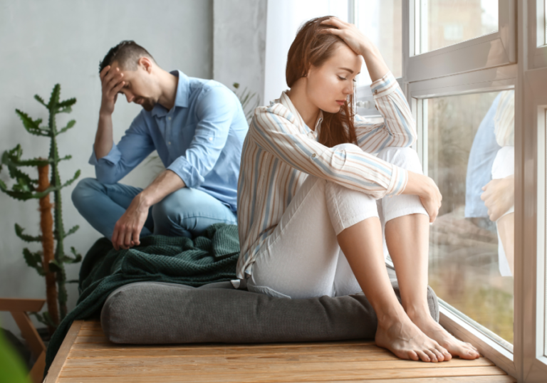 couple sitting by window sadly insecure woman with man