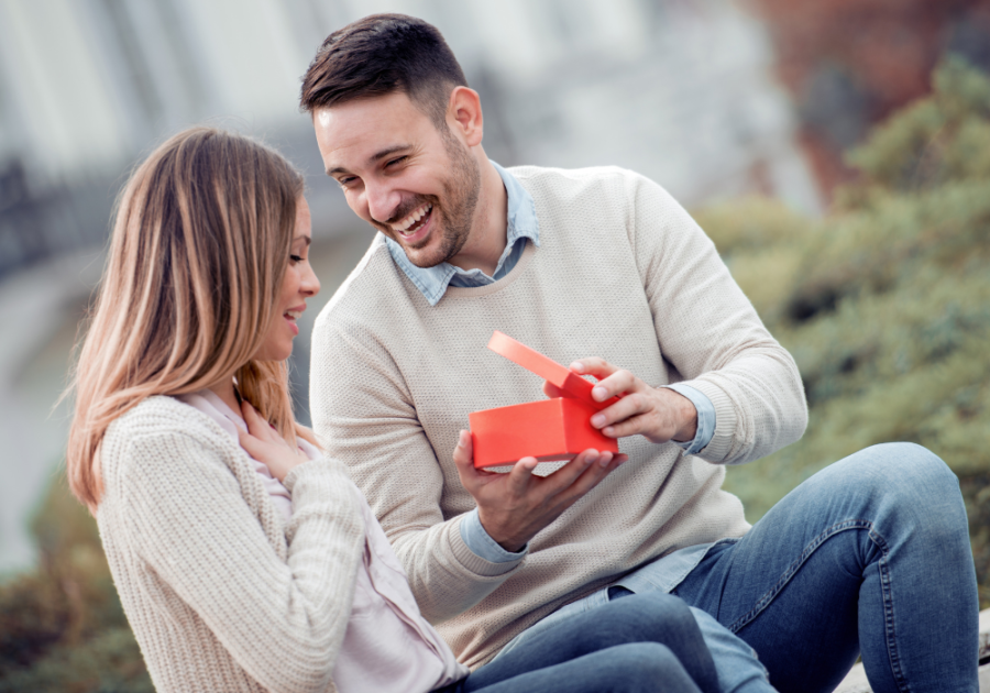 couple laughing man gives her gift Signs He Sees You As Special