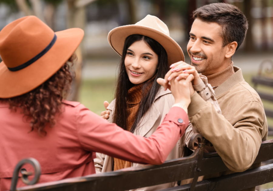 man and two women sitting on bench Polyamory vs. Open Relationship