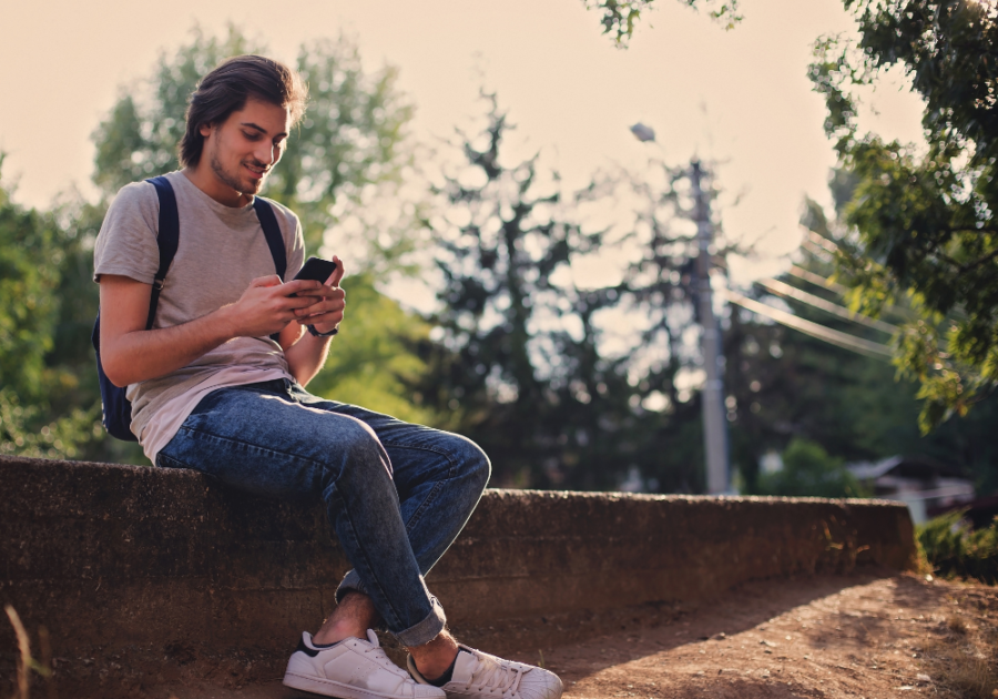 man sitting on bench using phone Good Morning Texts for Her