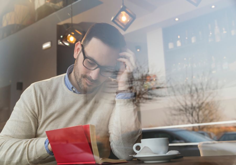 man reading a book in coffee shop High-Value Man Traits