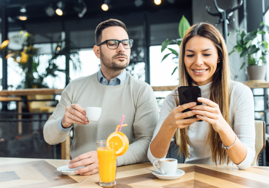 woman on phone with man looking on Find Out If Someone Is on a Dating Site