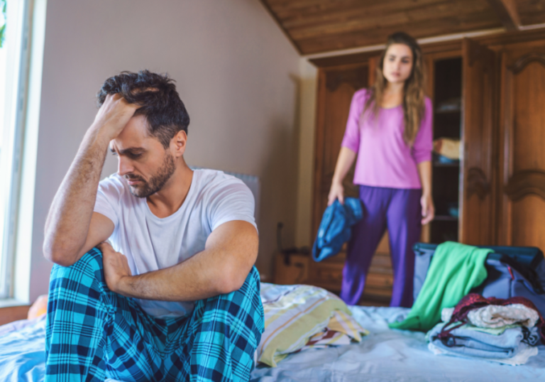 man sitting on bed woman standing breaking up with a narcissist