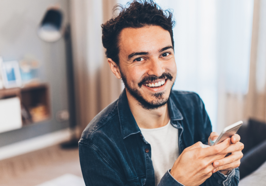 man holding phone smiling Good Morning Texts for Her