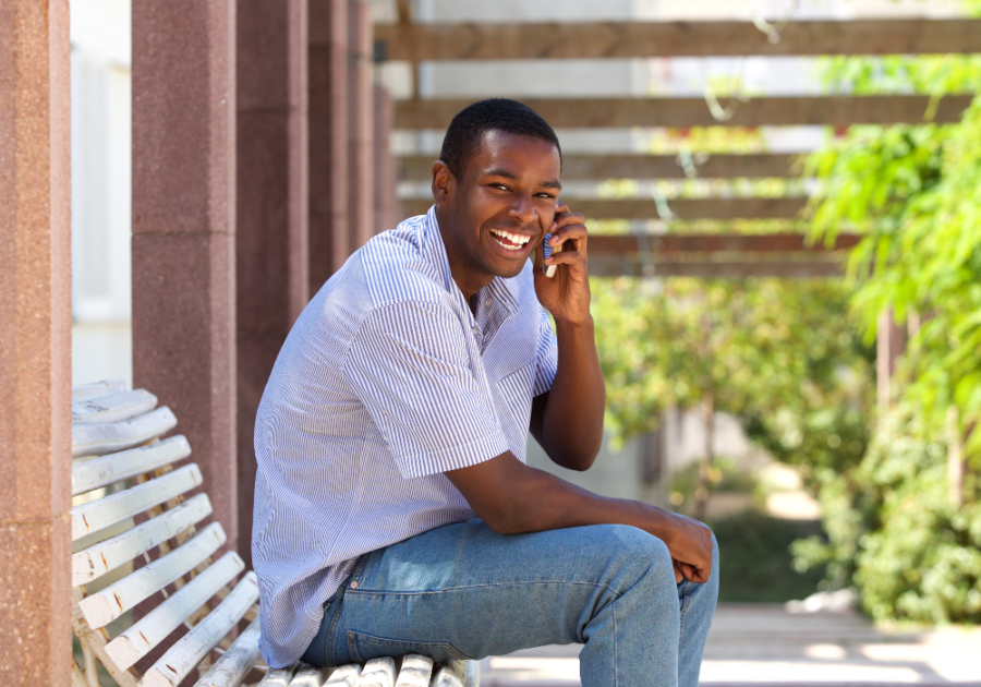 man sitting on bench laughing on phone Funny Ways to Answer the Phone