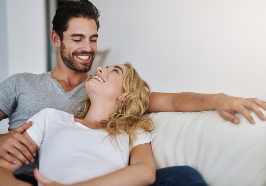 couple on sofa smiling at each other Respect Your Wife's Feelings