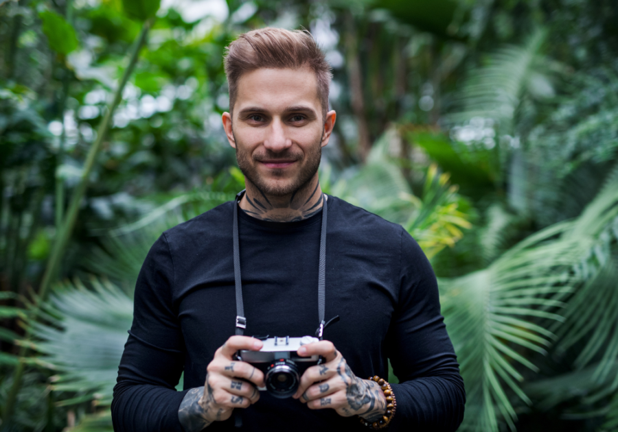 man in forest with camera leo man traits