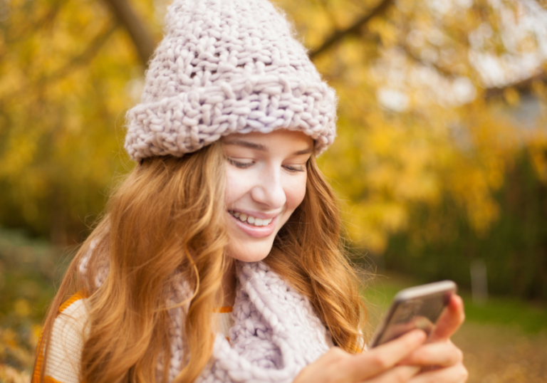 woman outside looking at phone start a conversation on Tinder