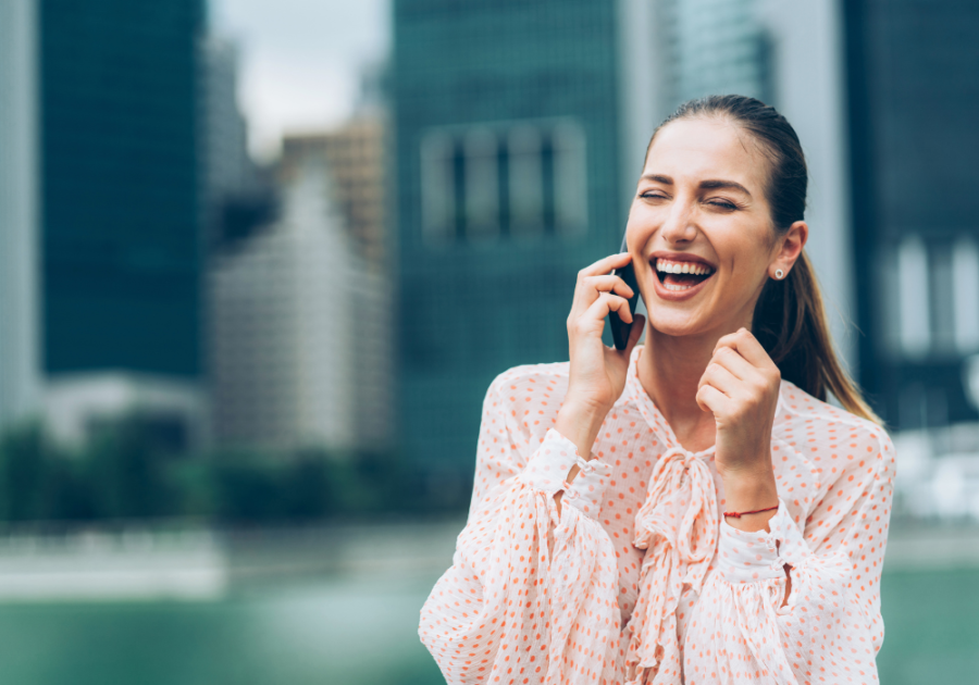 woman laughing on phone outdoors Funny Ways to Answer the Phone