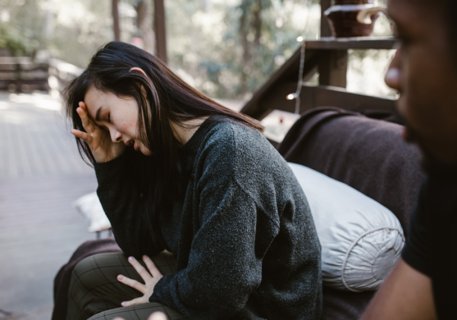 woman sitting on bench crying man watching Signs You Are Forcing a Relationship