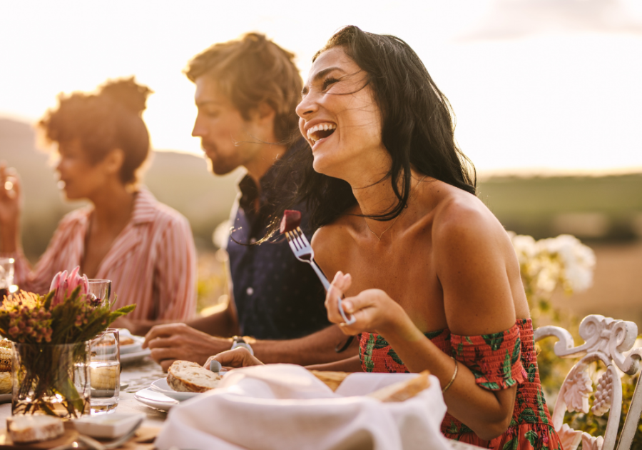 woman laughing at dinner outdoors Facts About The Aquarius Woman