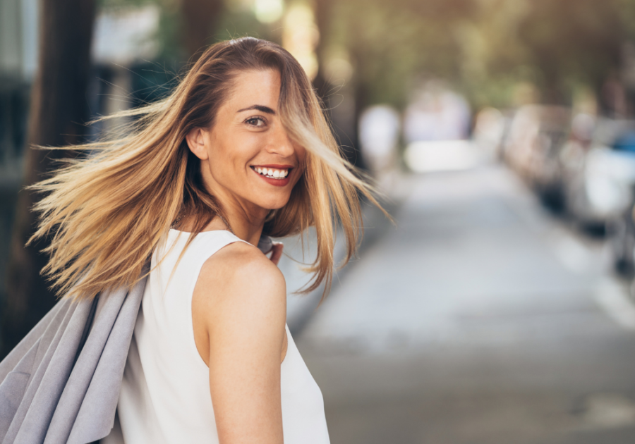 Woman walking down street smiling Facts About The Aquarius Woman