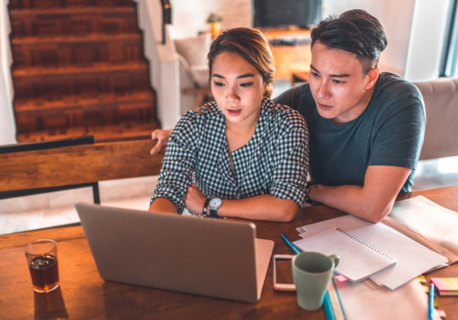 couple sitting together looking at computer compromise in a relationship