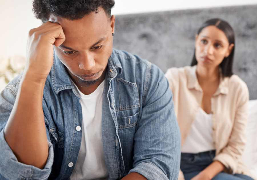 man sad with woman sitting behind him insecure man