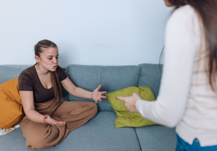 young woman sitting on sofa older woman standing i hate my mom