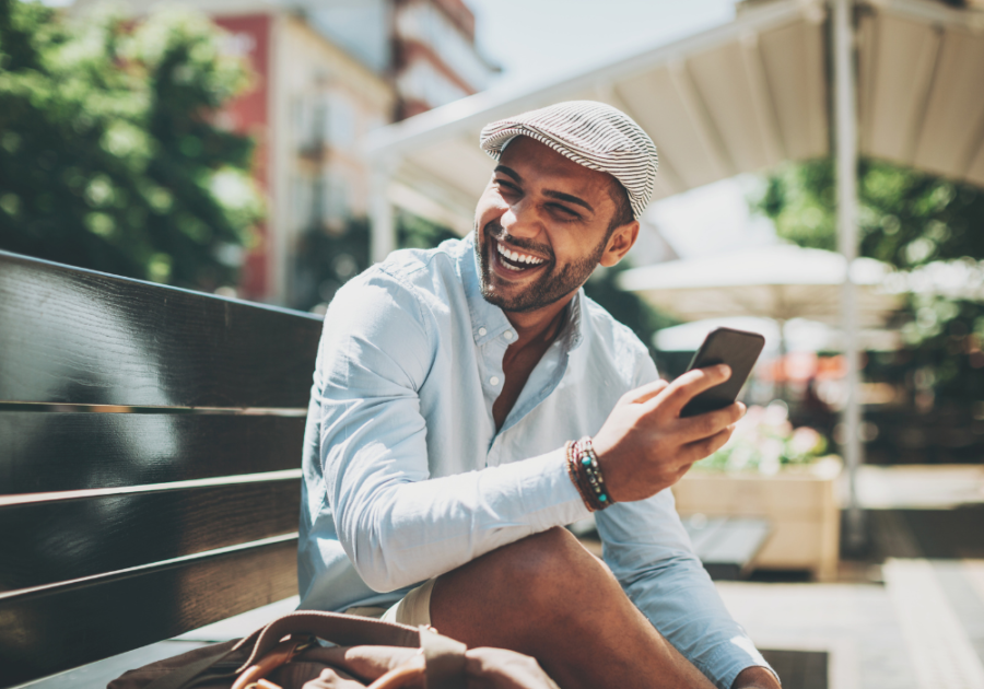 man sitting outside with phone laughing Truth or Dare Over Text