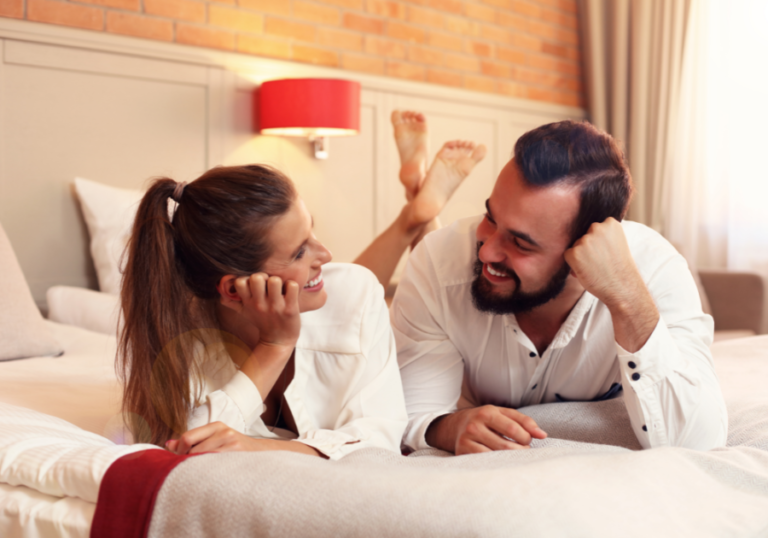 couple laying on bed talking Fun Questions to Ask Your Boyfriend 