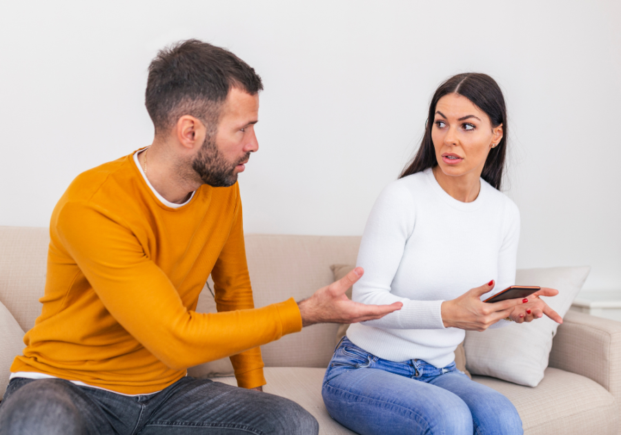 couple siting on sofa woman pulling away Snapchat Cheating