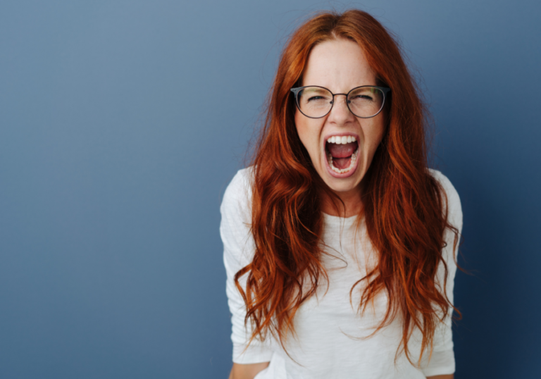 woman standing by wall screaming most dangerous zodiac sign when angry