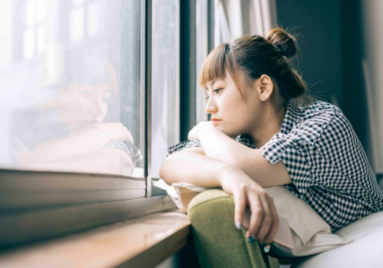 woman staring out window Signs You Will Never Find Love