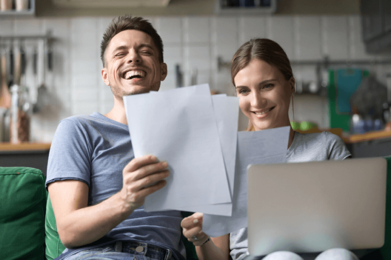 couple laughing on sofa Would You Rather Questions for Couples