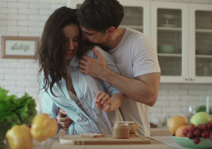 man hugging woman from behind Signs He Wants You Badly Sexually